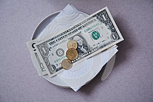 Restaurant tips or gratuity. Banknotes and coins on a plate photo