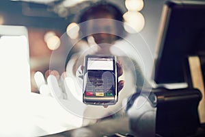 Restaurant waitress holding an electronic card payment machine