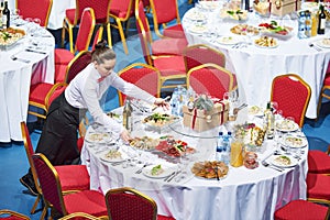 Restaurant waitress serving table with food