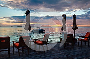 Restaurant on the water on the background of beautiful colorful sunset over the ocean