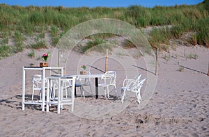 Restaurant white furniture on a sandy coast dune