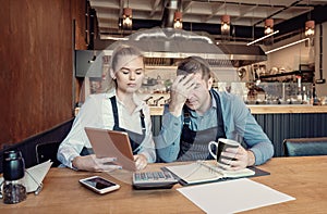 Restaurant young business owners checking papers after closing hours.