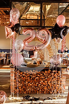 Restaurante room decorated for a birthday party with pink, black and transparent baloons of different sizes, large