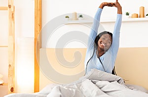 Rested African American Girl Waking Up Sitting In Cozy Bedroom