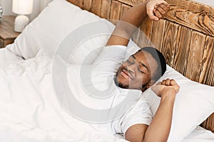Rested Black Man Waking Up Lying In Bed At Home