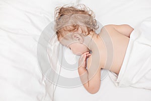 Restful two years old baby girl sleeping on bed