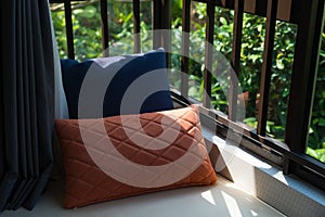 Resting area of a cozy window seat with cushions in the morning horizontal