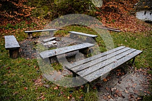 Resting place, camping covered with snow, fireplace, wooden benches and table in autumn forest, Hiking Golden Trail of Bohemian