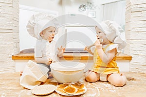 Restless cute caucasian grimy two-year-old kids in white cap