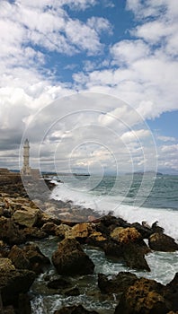 Restless rough sea with lots of waves and a famous lighthouse in city of Chania Crete, Greece