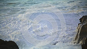 Restless sea washing rocks at morning seaside closeup. Ocean waves creating foam