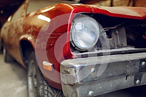 Restoration of classic car. Close up view front side classic car, front headlight of a broken dusty car during road