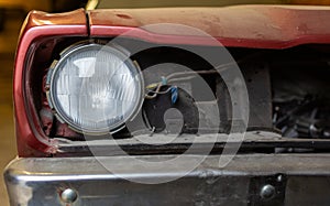 Restoration of classic car. Close up view front side classic car, front headlight of a broken dusty car during road accident and