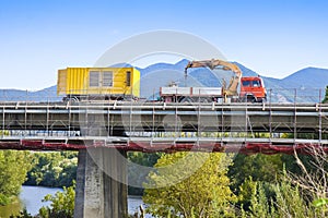 Restoration of an old damaged concrete bridge crossing a river with truck working