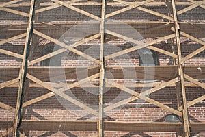 Restoration of an old red brick wall. scaffolding of wooden planks encircled the ancient defensive tower.