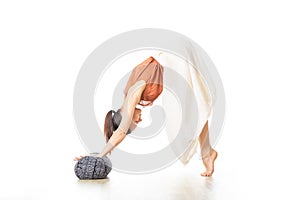 Restorative yoga with a bolster. Young sporty attractive woman in bright white yoga studio, stretching and relaxing