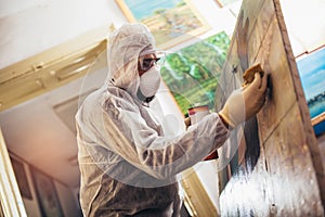 Restorer working on the painting at restoration workshop