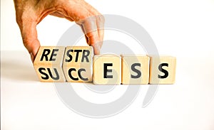 Restress for success symbol. Concept words Restress and Success on wooden cubes. Businessman hand. Beautiful white table white