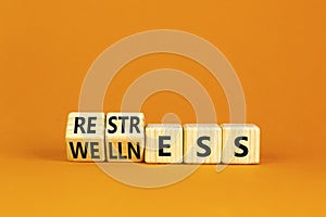 Restress for wellness symbol. Concept words Restress and Wellness on wooden cubes. Beautiful orange table orange background.