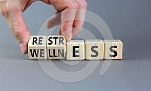 Restress for wellness symbol. Concept words Restress and Wellness on wooden cubes. Businessman hand. Beautiful grey table grey