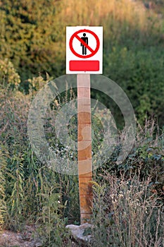 Restricted area do not enter authorized personnel only prohibited access with person icon metal sign on top of wooden board