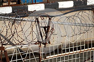 Restricted area. Passage is prohibited closed. Border from old barbed metal barrier wire. Concept of border, prison, war, military