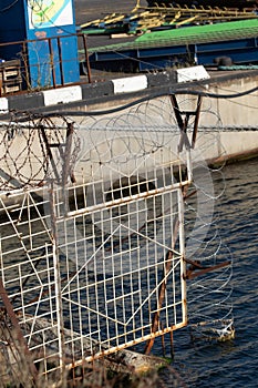 Restricted area. Passage is prohibited closed. Border from old barbed metal barrier wire. Concept of border, prison, war, military