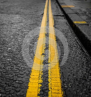 Restricted Parking, Close Up of Bright Double Yellow Lines on a Wet and Rainy Day - Norwich, UK photo