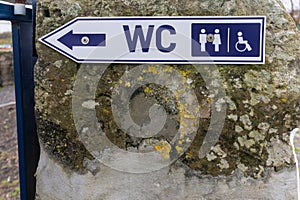 Restroom sign depicting both standard and disabled WC symbols.