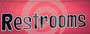 Restrooms sign on a red background