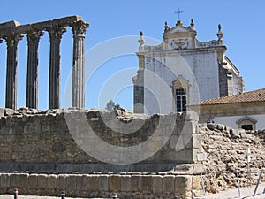 Rests of an old temple in front of a church to  Evora in Portugal.