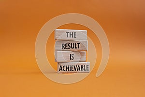 The result is achievable symbol. Concept words The result is achievable on wooden blocks. Beautiful orange background. Business