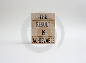 The result is achievable symbol. Concept words The result is achievable on wooden blocks. Beautiful white background. Business and