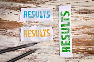 Results, Business concept. Torn sheets of paper on a white wooden background