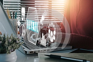 Person using laptop computer on desk with retail icon on virtual screen