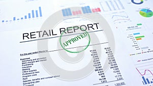 Retail report approved, hand stamping seal on official document, statistics