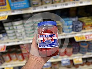 Retail store hand holding Big Johns Red Hots