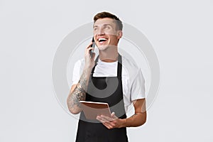 Retail stores, small business, cafe and restaurants takeaway concept. Handsome smiling salesman, barista talking on