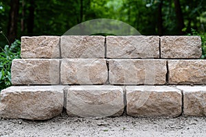 A retaining wall made of textured stone blocks.
