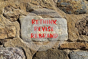 Rethink revise rebrand symbol. Concept word Rethink Revise Rebrand on beautiful big stone. Beautiful stone wall background.
