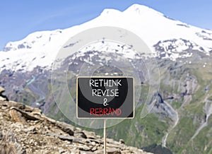 Rethink revise rebrand symbol. Concept word Rethink Revise and Rebrand on beautiful blackboard. Beautiful mountain background.