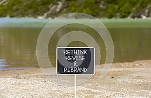 Rethink revise rebrand symbol. Concept word Rethink Revise and Rebrand on beautiful blackboard. Beautiful mountain background.