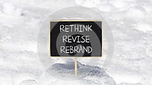 Rethink revise rebrand symbol. Concept word Rethink Revise Rebrand on beautiful blackboard. Beautiful white snow background.