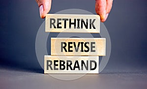 Rethink revise rebrand symbol. Concept word Rethink Revise Rebrand on beautiful block. Beautiful grey table grey background.