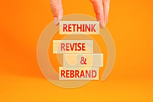 Rethink revise rebrand symbol. Concept word Rethink Revise and Rebrand on beautiful block. Beautiful orange background. Business