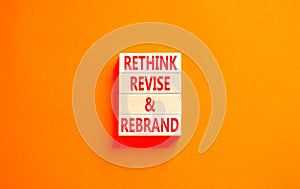 Rethink revise rebrand symbol. Concept word Rethink Revise and Rebrand on beautiful block. Beautiful orange background. Business