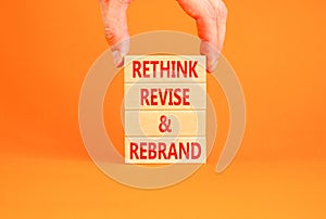 Rethink revise rebrand symbol. Concept word Rethink Revise and Rebrand on beautiful block. Beautiful orange background. Business