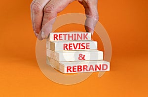 Rethink revise rebrand symbol. Concept word Rethink Revise and Rebrand on beautiful block. Beautiful orange background. Business