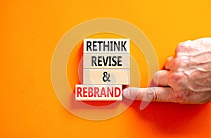 Rethink revise rebrand symbol. Concept word Rethink Revise and Rebrand on beautiful block. Beautiful orange background. Business