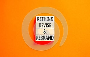 Rethink revise rebrand symbol. Concept word Rethink Revise and Rebrand on beautiful block. Beautiful orange background. Business